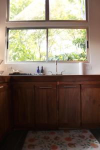 a kitchen with a large window above a sink at The Emerald Haven in Parrita