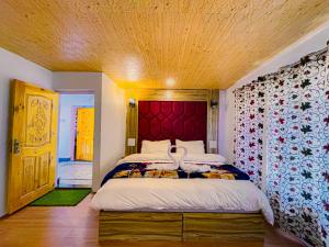 a bedroom with a large bed with a red headboard at Snow Touch Pahalgam in Pahalgām +5 photos