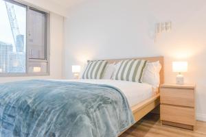 ein weißes Schlafzimmer mit einem Bett und einem Fenster in der Unterkunft Family Harbour Escape with Harbour Views & Parking in Sydney + 18 Fotos