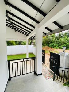 a white porch with a black and white railing at Himeth's Residence in Weliweriya