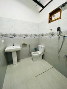 a bathroom with a sink and a toilet and a shower at Himeth's Residence in Weliweriya