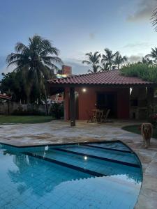 a swimming pool in front of a house at Petit Thay Home in Cumbuco +10 photos
