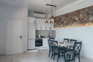 a kitchen with a table and chairs and a kitchen with white cabinets at Art residence villa in Bar