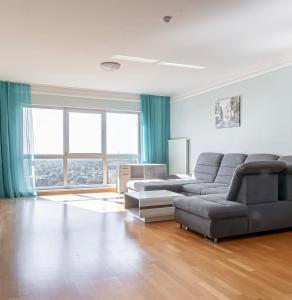 リガにあるPanorama Riga 25th Floor Spacious Apartment Free Parkingのソファとテーブルのあるリビングルーム