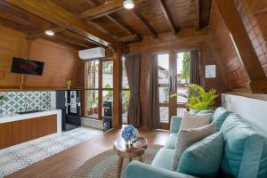 a living room with a blue couch and a kitchen at Alamora Villa - New Stylish 1BR Villa, Canggu in Dalung