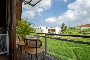 a balcony with a table and chair and a view at Alamora Villa - New Stylish 1BR Villa, Canggu in Dalung