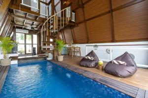 a swimming pool with pillows next to a house at Alamora Villa - New Stylish 1BR Villa, Canggu in Dalung