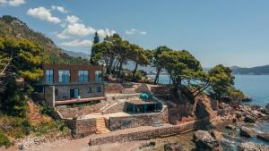 a house on a cliff next to the water at Art residence villa in Bar +23 photos