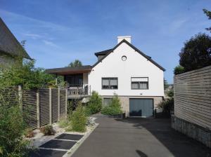a white house with a fence and a driveway at Maison les pieds dans l'eau in Trébeurden