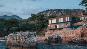a house on the side of a rock in the water at Art residence villa in Bar