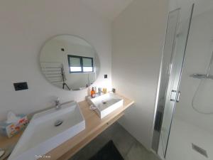 a white bathroom with a sink and a mirror at Maison les pieds dans l'eau in Trébeurden +33 photos