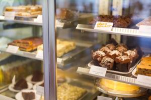 a display case with different types of cakes and pastries at Loch Ness Drumnadrochit Hotel in Drumnadrochit