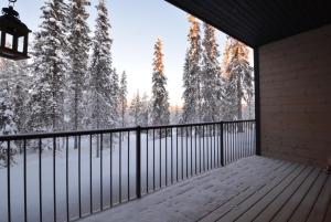 a balcony of a house with snow covered trees at Vanhamylly AS 4 in Äkäslompolo