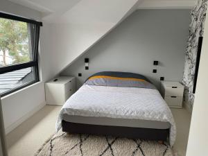 a white bedroom with a bed and a window at Maison les pieds dans l'eau in Trébeurden