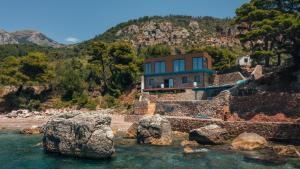 a house on a hill next to the water at Art residence villa in Bar