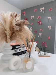 Un grupo de jarrones blancos sobre una mesa con libros. en Ueno Rose, en Tokio