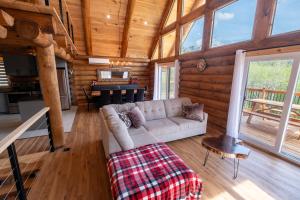 a living room with a couch in a log cabin at Spa and Mountain - Le Tennessee Whiskey in Saint-Philémon +40 photos