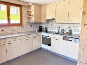 a kitchen with white cabinets and white appliances at Ferienwohnung Bergblick in Sedrun