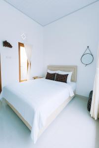 Ένα ή περισσότερα κρεβάτια σε δωμάτιο στο Puri Indah Inn Guest House