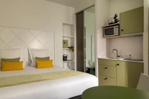 a bedroom with a bed with yellow pillows and a microwave at Villa Diana in Molsheim