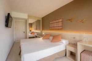 a bedroom with a large white bed in a room at Garden Saladina - Adults Only in Playa de Muro