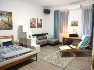 セゲドにあるThomas' Apartmanのベッドと机とソファのある寝室