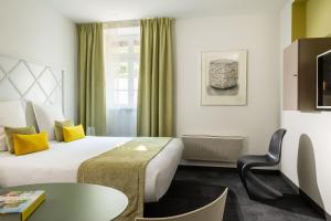 a hotel room with a bed and a table at Villa Diana in Molsheim