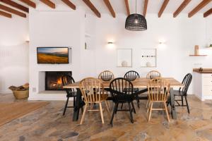 a dining room with a table and chairs and a fireplace at Las Rocas in Fornalutx