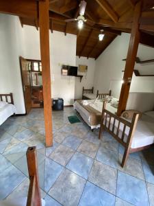 a room with two beds and a tv in it at Pousada Aqui é Para-Ti in Paraty