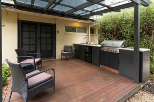a patio with an outdoor kitchen and a grill at Adina Lodge Holiday Apartments in Bright