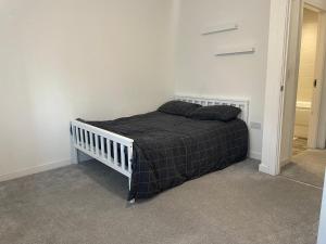 a bedroom with a bed with a black blanket at Tyldesley Manor in Tyldesley