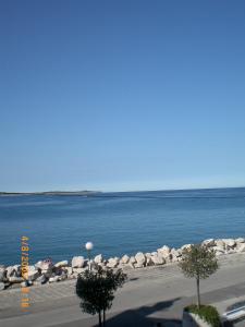 a view of a body of water with rocks and trees at Apartments Maja in Piran