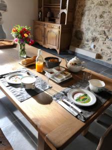 a wooden table with plates of food on it at Chambres Tables d'Hôtes Lukugaraia in Iholdy
