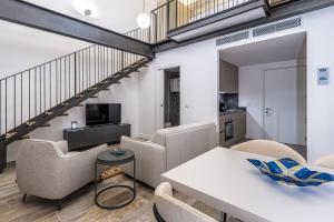 a living room with a table and chairs and a staircase at Old Theatre Suites - Ischia in Valletta