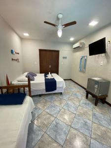 a bedroom with two beds and a flat screen tv at Pousada Aqui é Para-Ti in Paraty