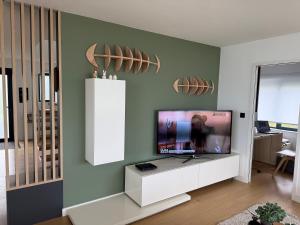 a living room with a flat screen tv on a wall at Maison les pieds dans l'eau in Trébeurden