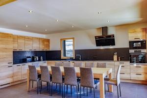 a kitchen with a wooden table and chairs at La Licorne de l'Encombrette 150 m2 in Allos