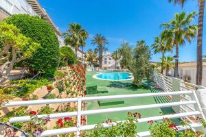 a view of a swimming pool with palm trees and plants at SUENO by the Sea in Dehesa de Campoamor