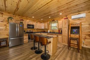 a kitchen with wooden cabinets and a stainless steel refrigerator at Tridents Creek by American Patriot Getaways in Rocky Grove