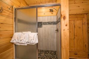 a shower in a wooden bathroom with white towels at Tridents Creek by American Patriot Getaways in Rocky Grove +33 photos