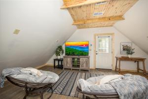a attic room with two beds and a tv at Tridents Creek by American Patriot Getaways in Rocky Grove