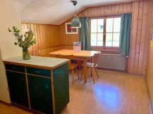 a room with a table and a vase of flowers at Ferienwohnung Dachnest in Sedrun