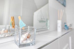 a white counter with two clear containers on it at Huus achtern Diek - Ferienwohnung 5 in Nordstrand +23 photos