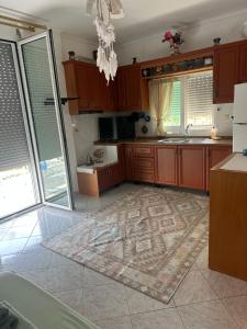 a kitchen with wooden cabinets and a rug on the floor at Joannas Stefaneli House in Himare +51 photos