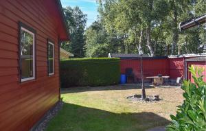 un cortile accanto a una casa rossa con un patio di Two Bedroom Awesome Home In Nybrostrand a Kabusa