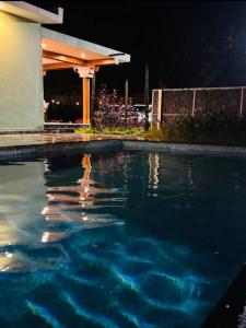 a swimming pool in front of a house at night at Sunrise Retreat - Kabini in Hampāpura