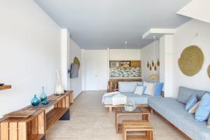 ein Wohnzimmer mit einem Sofa und einem Tisch in der Unterkunft Apartamentos Castaví in Es Pujols