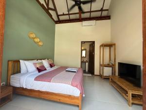 una camera da letto con un letto e una TV a schermo piatto di Dream Divers Gili Air Seaside Boutique Escape a Gili Air