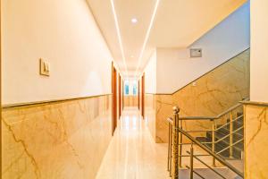 a hallway of a building with marble walls and stairs at Hotel O Delight Stay in Indore