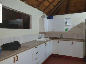 a kitchen with white cabinets and a sink at Inkonka Game farm in Uitsig